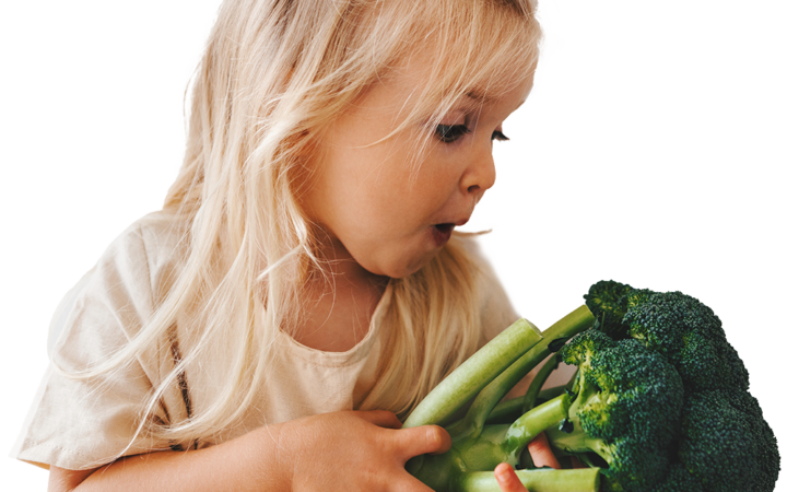 Child holding fresh broccoli for a Chefs Feeding Kids nutrition program