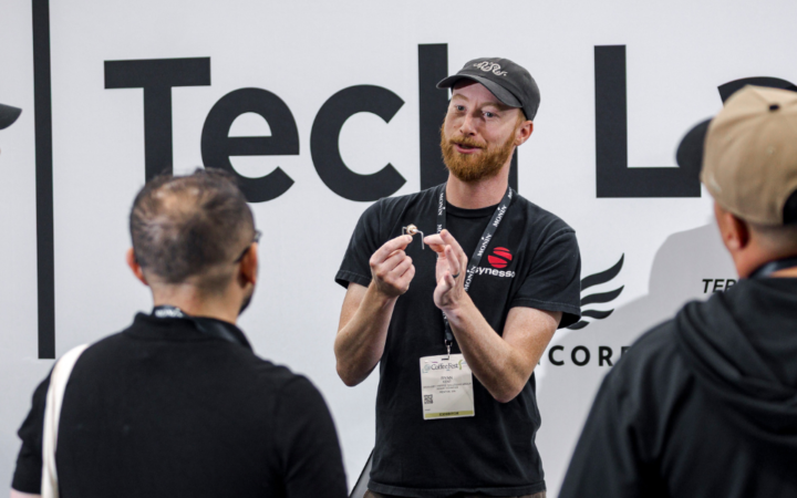 Coffee professionals working with espresso equipment in the Coffee Fest Tech Lab