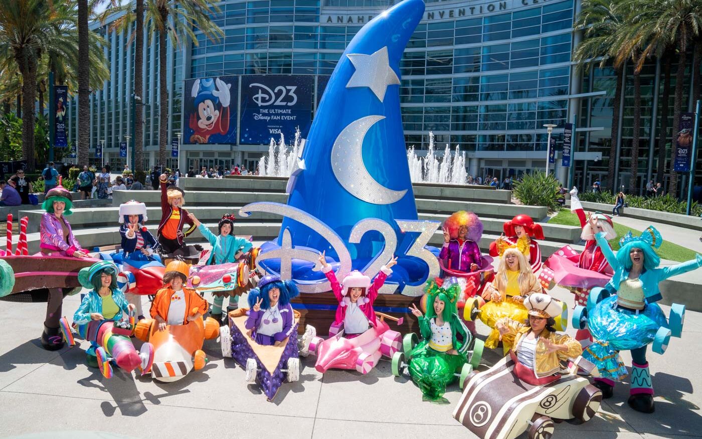 Colorful Sugar Rush cosplayers pose around the D23 Sorcerer Mickey hat outside the Anaheim Convention Center