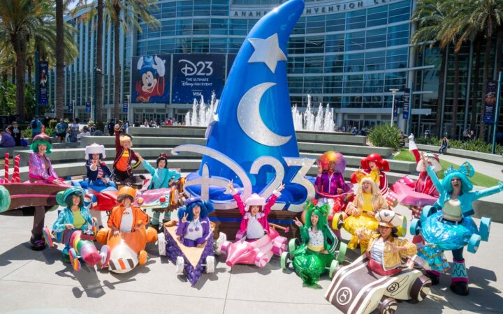 Colorful Sugar Rush cosplayers pose around the D23 Sorcerer Mickey hat outside the Anaheim Convention Center