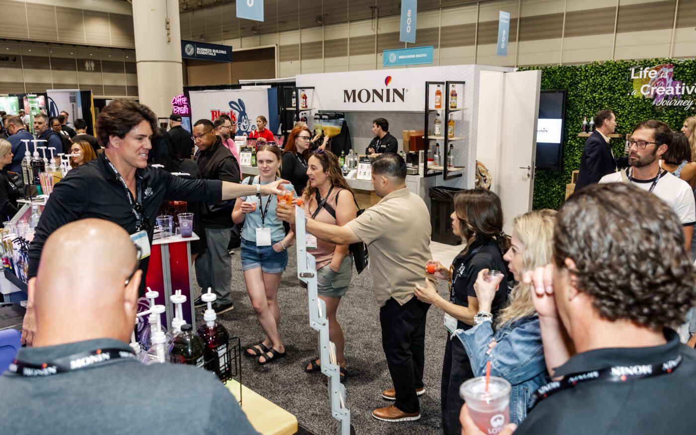 Attendees at exhibitor booths on the Coffee Fest floor