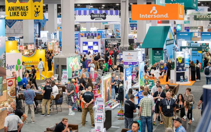 A busy SUPERZOO exhibition floor filled with pet product brands and buyers