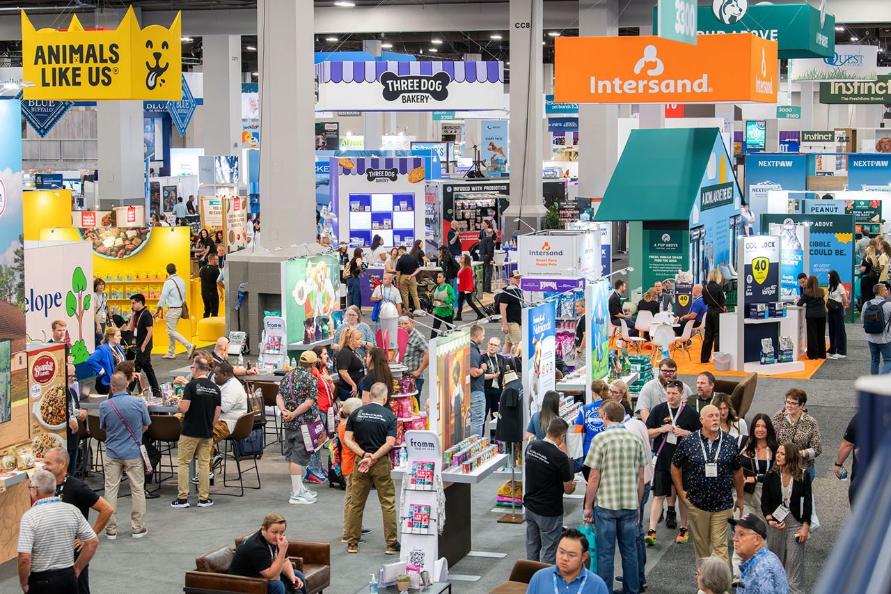 A busy SUPERZOO exhibition floor filled with pet product brands and buyers