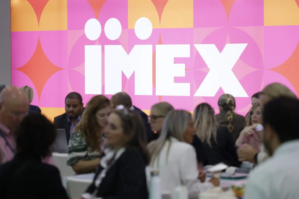 Attendees at an IMEX branded wall