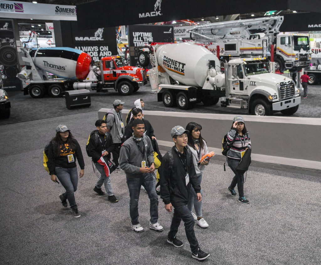 Attendees among concrete mixer trucks