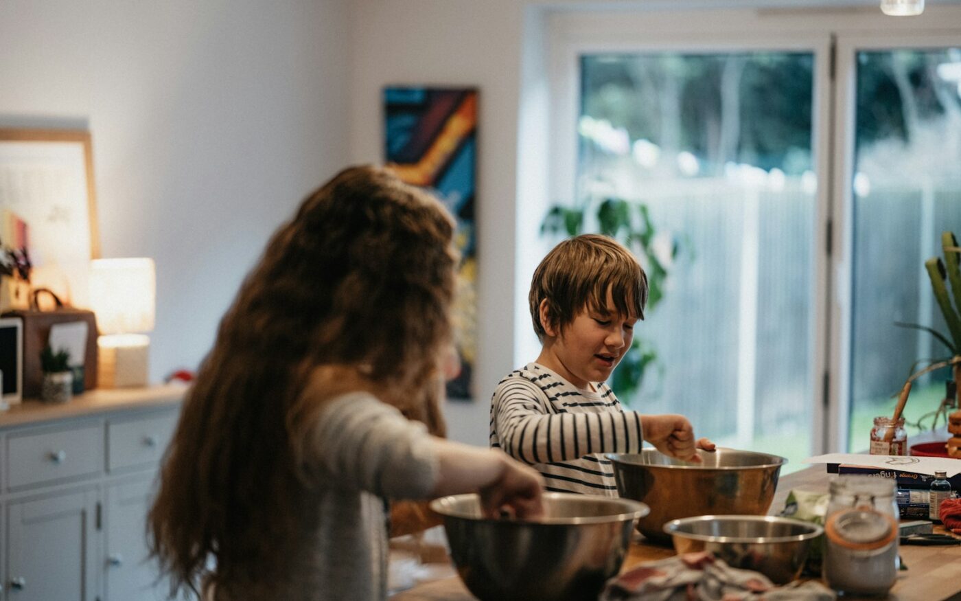 Two children mixing ingredients in a kitchen