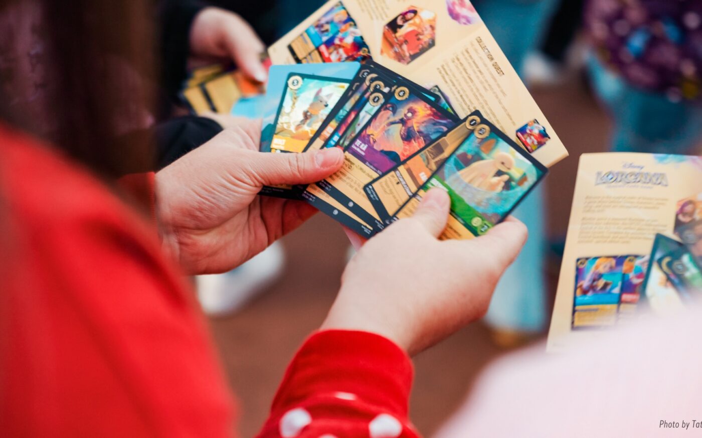 A D23 guest holds Disney Lorcana trading cards