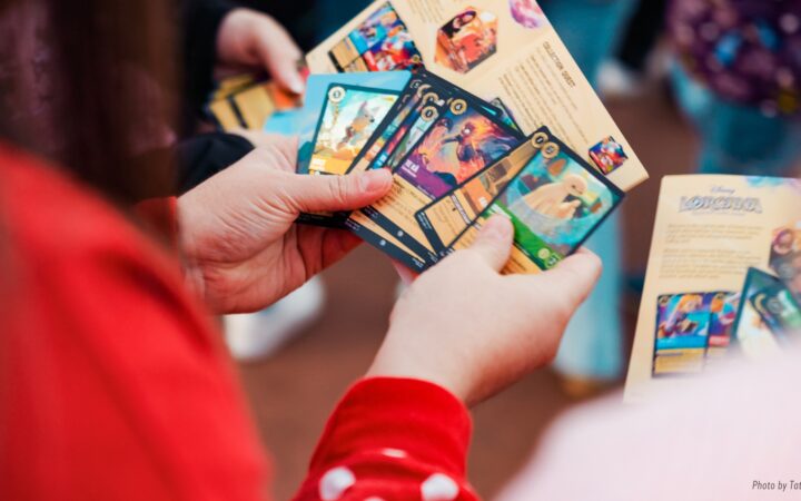 A D23 guest holds Disney Lorcana trading cards