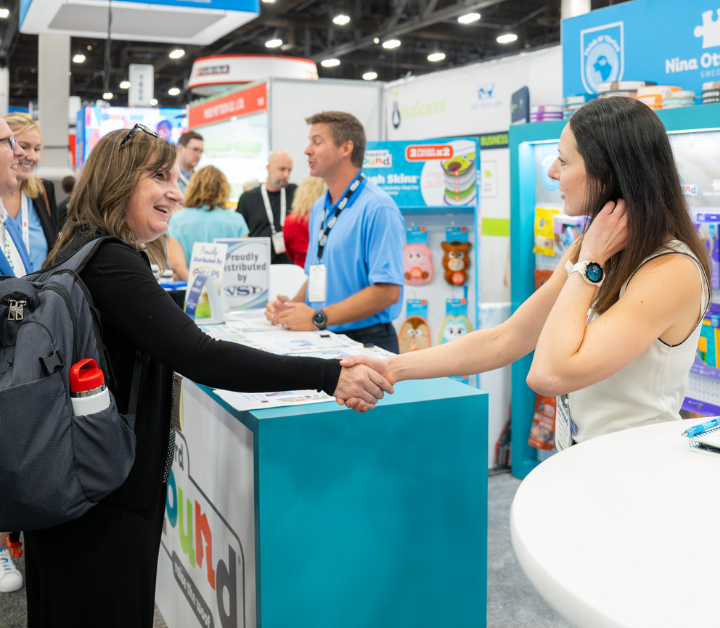 A pet retailer and exhibitor begin a conversation on the SUPERZOO show floor