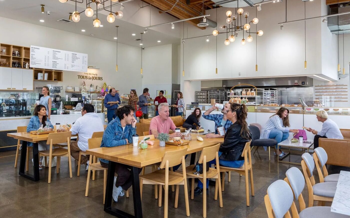 Bright TOUS les JOURS bakery café filled with customers and pastry displays