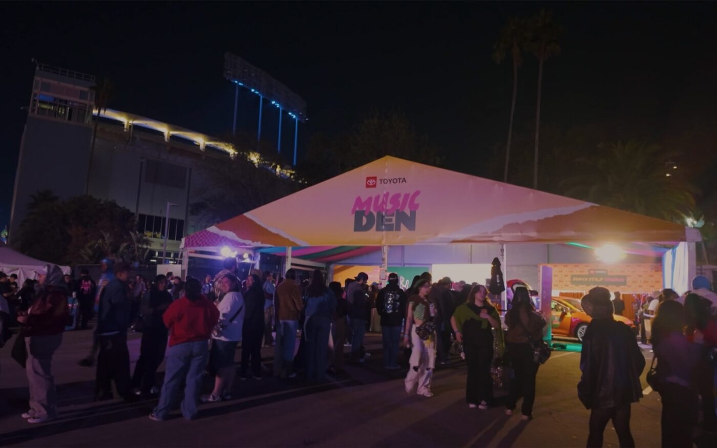 Crowd gathered outside the illuminated Toyota Music Den at night